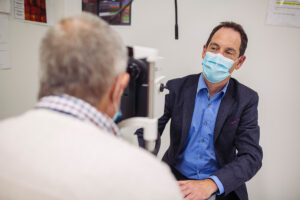 Pro Keith Martin, looking at a clincila trial participant thugh an ophthalmic device