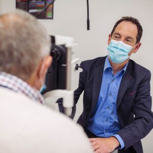 Pro Keith Martin, looking at a clincila trial participant thugh an ophthalmic device