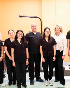 A group of clinicians in black scrubs standing together in an ophthalmic clinic