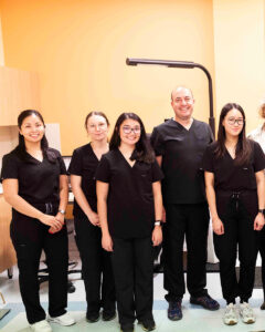 A group of clinicians in black scrubs standing together in an ophthalmic clinic