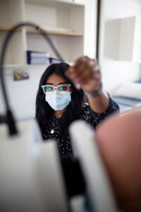 A clinician adjusting a section of a camera.