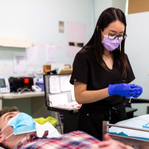 A participant lies on a table while a clinician prepares a syringe